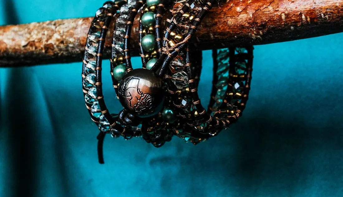 Wrap bracelets hanging on a branch against teal fabric