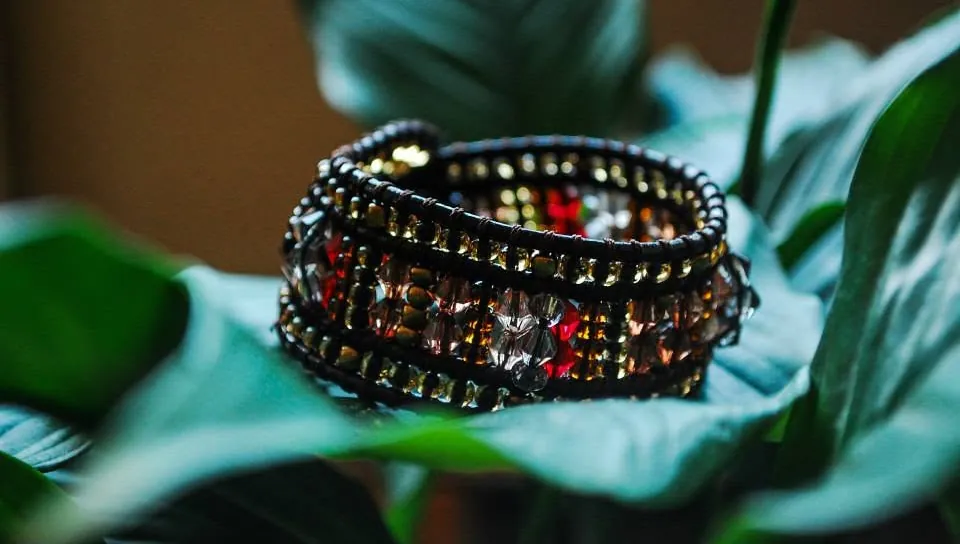 Close-up of a beaded cuff resting on green leaves